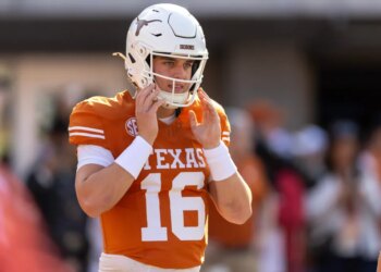 Texas Longhorns football player Quinn Ewers in his white helmet with a longhorn logo and orange jersey with number 16.