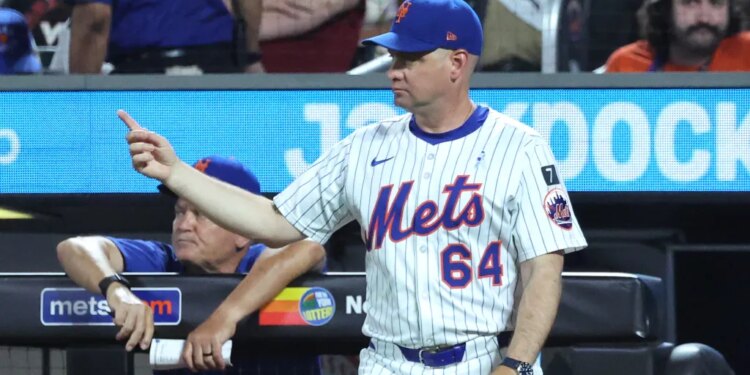 New York Mets manager Carlos Mendoza #64 signals for a new pitcher during the 6th inning.