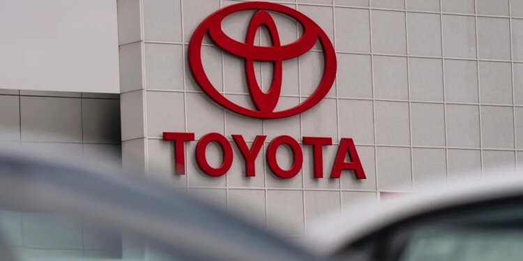 Red Toyota logo and name on the side of a dealership building.