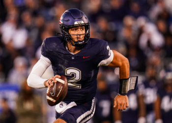 UConn quarterback holds a football.