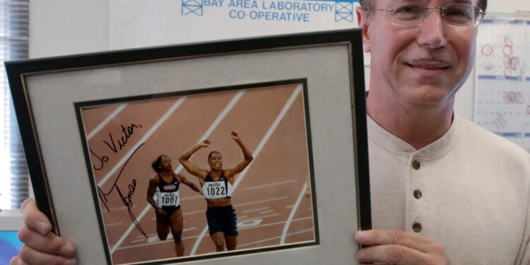 Victor Conte holds up an autographed photo addressed to Conte of track star Marion Jones in his office in Burlingame, Calif., Oct. 21, 2003.