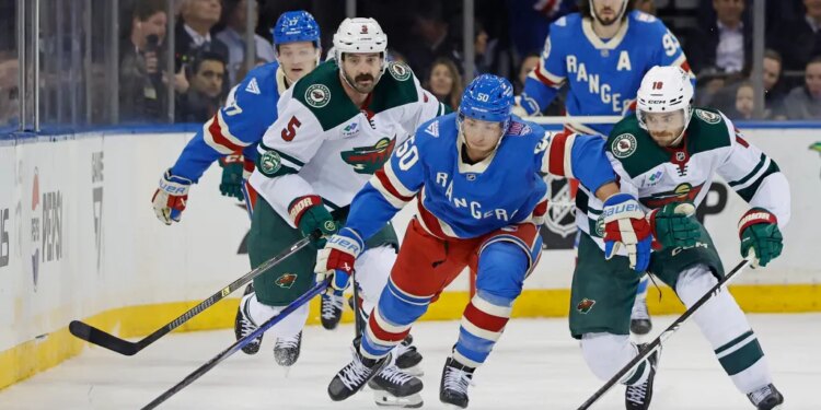 Rangers left wing Will Cuylle passes the puck as Minnesota Wild center Vinnie Hinostroza tries to steal it in the first period at Madison Square Garden in New York, October 20, 2025.