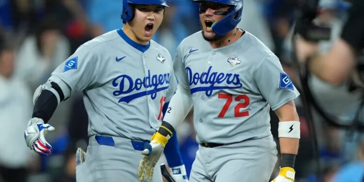 Los Angeles Dodgers second baseman Miguel Rojas (72) and two-way player Shohei Ohtani (17) celebrating after scoring in the ninth inning of game seven of the 2025 MLB World Series.