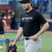 New York Yankees pitcher Gerrit Cole in a black Yankees t-shirt and hat, holding a black glove.