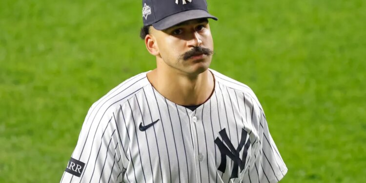 Trent Grisham of the New York Yankees looking up while wearing his uniform, cap, and a mustache.