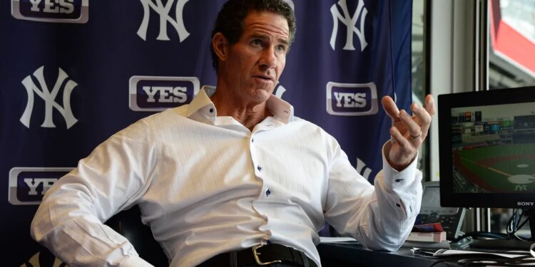 Paul O'Neill speaking with a monitor showing a baseball game and New York Yankees and YES Network logos in the background.