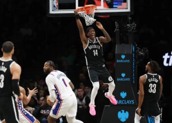 Brooklyn Nets guard Terance Mann (14) hangs on the rim after a missed dunk attempt during the second half of a game against the Philadelphia 76ers at Barclays Center in Brooklyn, N.Y. on Sunday, Nov. 2, 2025.