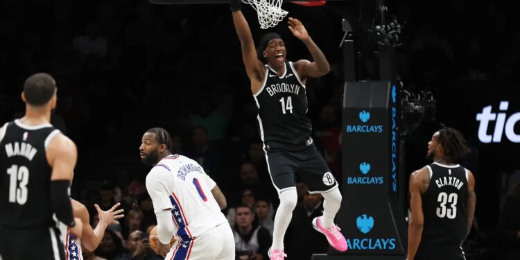 Brooklyn Nets guard Terance Mann (14) hangs on the rim after a missed dunk attempt during the second half of a game against the Philadelphia 76ers at Barclays Center in Brooklyn, N.Y. on Sunday, Nov. 2, 2025.