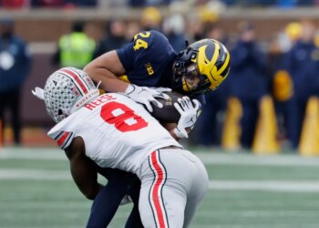 Michigan Wolverines running back Bryson Kuzdzal (24) is tackled by Ohio State Buckeyes linebacker Arvell Reese (8).