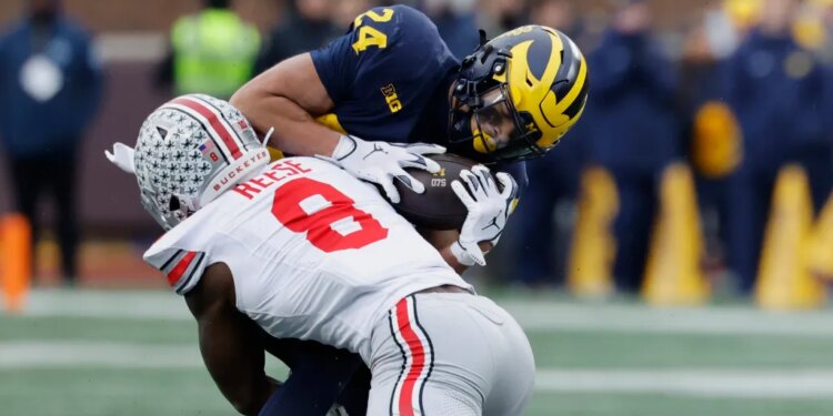 Michigan Wolverines running back Bryson Kuzdzal (24) is tackled by Ohio State Buckeyes linebacker Arvell Reese (8).