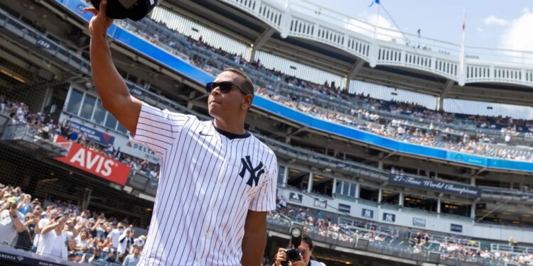 Alex Rodriguez salutes fans, holding his baseball cap in the air, during Old Timer’s Day.