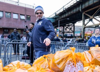 New York Yankees manager Aaron Boone, the 44th precinct and the Food Bank of New York City are distributing food and toys to 500 neighborhood families, Friday, Dec. 19, 2025, in Bronx, NY.