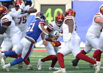 Linebacker Abdul Carter #51 of the New York Giants sacks quarterback Marcus Mariota #8 of the Washington Commanders.