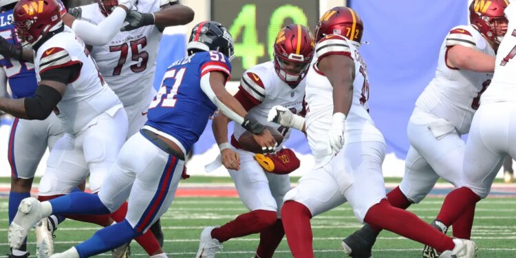 Linebacker Abdul Carter #51 of the New York Giants sacks quarterback Marcus Mariota #8 of the Washington Commanders.