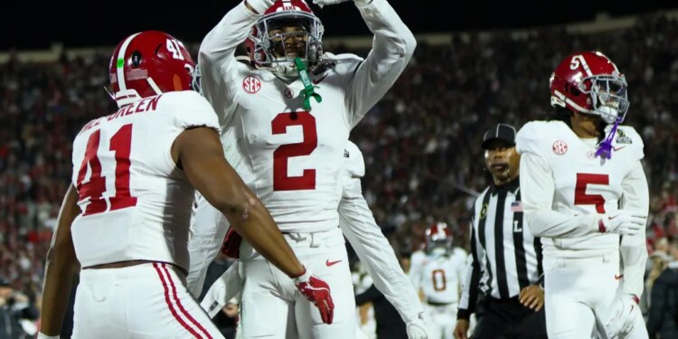 Alabama defensive back Zabien Brown (2) forms a heart shape with his hands while celebrating his touchdown with teammate #41 during a football game.