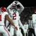 Alabama defensive back Zabien Brown (2) forms a heart shape with his hands while celebrating his touchdown with teammate #41 during a football game.