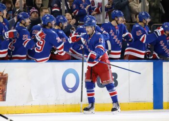 New York Rangers left wing Alexis Lafrenière (13) is greeted by his teammates on the bench after scoring a goal during the second period.