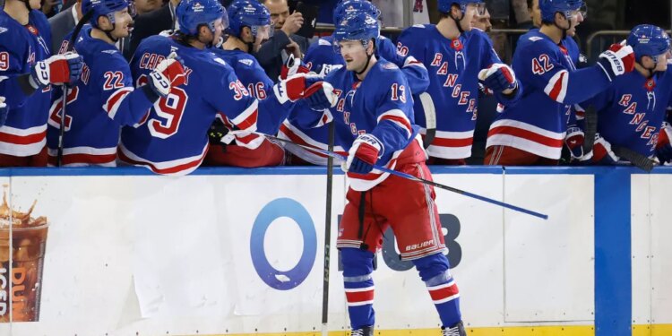 New York Rangers left wing Alexis Lafrenière (13) is greeted by his teammates on the bench after scoring a goal during the second period.