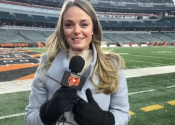 Elise Jesse, a Bengals reporter, holding a microphone in a stadium.