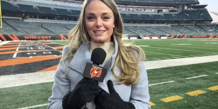 Elise Jesse, a Bengals reporter, holding a microphone in a stadium.