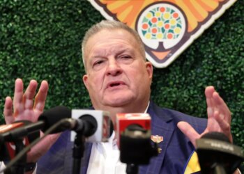 Michigan interim head coach Biff Poggi answers a question during a Citrus Bowl news conference.