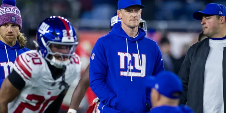 New York Giants interim defensive coordinator Charlie Bullen in a blue hoodie and cap on the field.