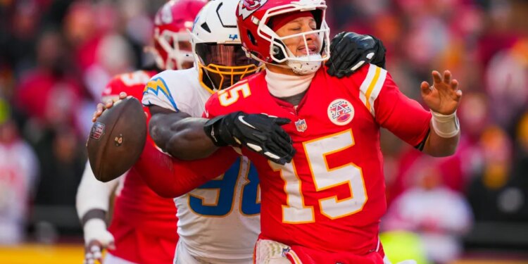 Los Angeles Chargers linebacker Odafe Oweh (98) sacks Kansas City Chiefs quarterback Patrick Mahomes (15) during the second half at GEHA Field at Arrowhead Stadium.