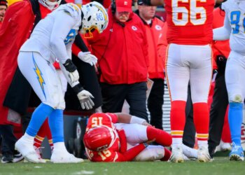 Kansas City Chiefs quarterback Patrick Mahomes (15) on the ground as Chargers defensive tackle Justin Eboigbe (92) and Chiefs head coach Andy Reid watch.