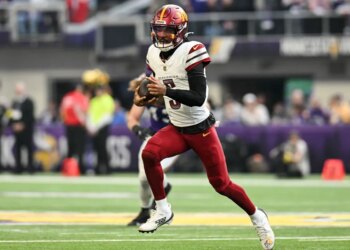 Washington Commanders quarterback Jayden Daniels (5) rushes the ball against the Minnesota Vikings during the first half at U.S. Bank Stadium.