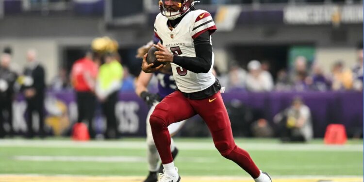 Washington Commanders quarterback Jayden Daniels (5) rushes the ball against the Minnesota Vikings during the first half at U.S. Bank Stadium.