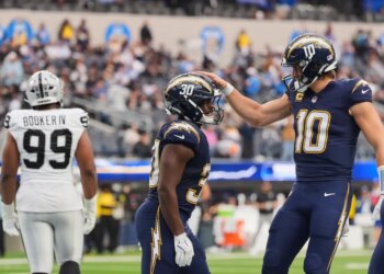 Los Angeles Chargers running back Kimani Vidal (30) celebrates with quarterback Justin Herbert (10) after scoring a touchdown against the Las Vegas Raiders.