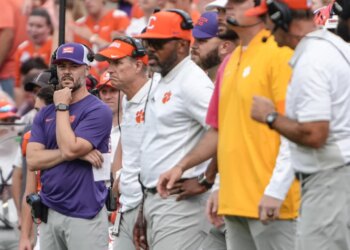 Clemson Tigers offensive coordinator Garrett Riley and other coaches on the sideline.