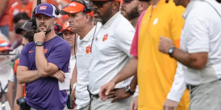 Clemson Tigers offensive coordinator Garrett Riley and other coaches on the sideline.