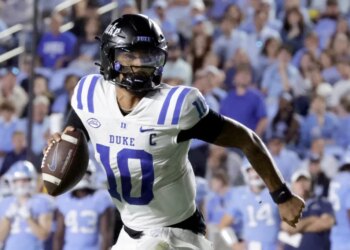 Duke quarterback Darian Mensah (10) rolls out during a college football game against North Carolina.