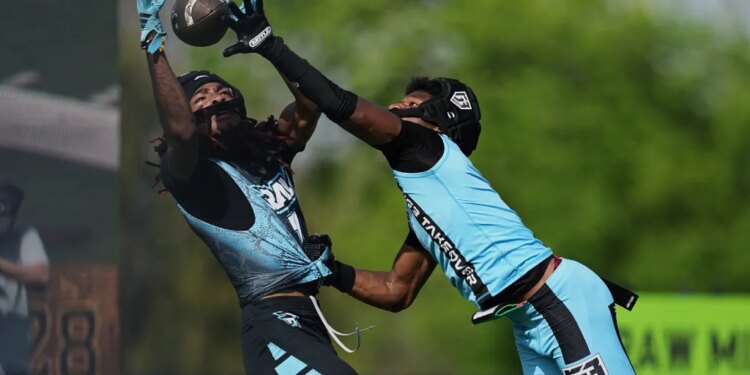 Raw Miami wide receiver Calvin Russell, left, catches a touchdown pass in front of RG3 Takover's Chris Stewart, right, during OT7 football Week 3, Saturday, March 29, 2025, in Dallas.