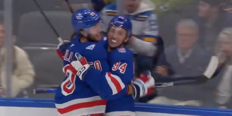 Two hockey players from the New York Rangers celebrating a goal.