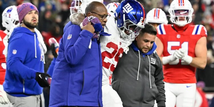 New York Giants running back Tyrone Tracy Jr. (29) is helped off the field.