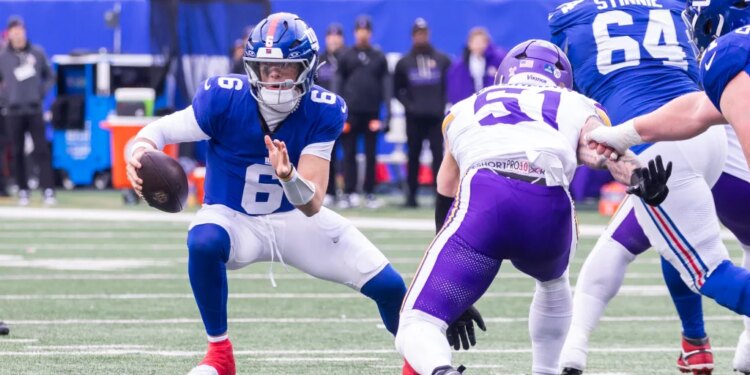 Quarterback Jaxson Dart #6 of the New York Giants is forced out of the pocket by linebacker Blake Cashman #51 of the Minnesota Vikings during the first half at MetLife Stadium, Sunday, Dec. 21, 2025, in East Rutherford, New Jersey.