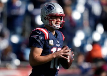 Falcons Patriots Football player holding a football.