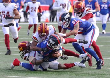 Quarterback Jaxson Dart of the New York Giants is tackled by safety Will Harris of the Washington Commanders.