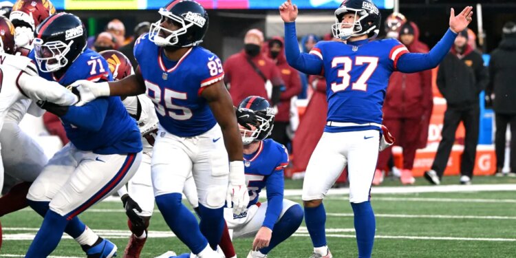 New York Giants place kicker Younghoe Koo #37 raising his arms after kicking a field goal.