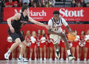Ian Jackson #11 of the St. John's Red Storm drives down court as Ben Eisendrath #5 of the Harvard Crimson gives chase during the second half.
