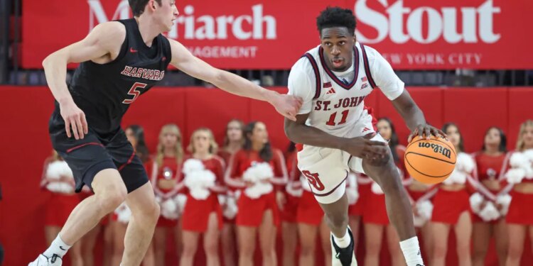 Ian Jackson #11 of the St. John's Red Storm drives down court as Ben Eisendrath #5 of the Harvard Crimson gives chase during the second half.