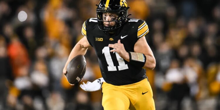 Iowa Hawkeyes quarterback Mark Gronowski (11) scrambles for yards.