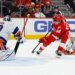 Detroit Red Wings center Emmitt Finnie (58) skates with the puck defended by New York Islanders defenseman Matthew Schaefer (48) in the second period at Little Caesars Arena.