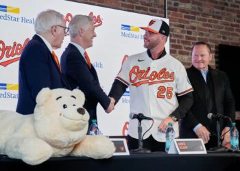 Orioles first baseman Pete Alonso (25) shakes hands with Orioles president of baseball operations Mike Elias, as Orioles owner David Rubenstein, left, and sports agent Scott Boras, right, look on during a baseball press conference, Friday, Dec. 12, 2025.