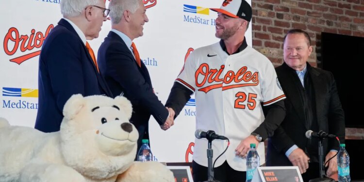 Orioles first baseman Pete Alonso (25) shakes hands with Orioles president of baseball operations Mike Elias, as Orioles owner David Rubenstein, left, and sports agent Scott Boras, right, look on during a baseball press conference, Friday, Dec. 12, 2025.