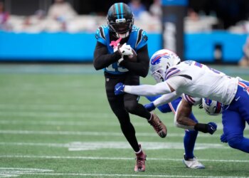 Carolina Panthers quarterback Hendon Hooker (12) runs against Buffalo Bills cornerback Taron Johnson (7).