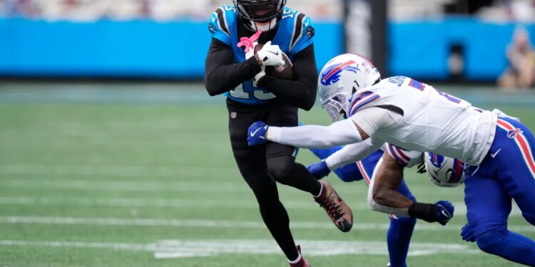 Carolina Panthers quarterback Hendon Hooker (12) runs against Buffalo Bills cornerback Taron Johnson (7).
