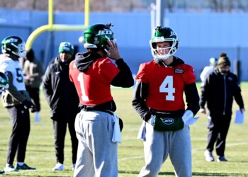 Brady Cook (right) on the Jets practice field.